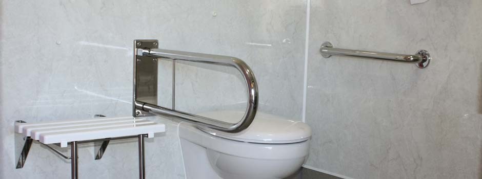 inside view of disabled shower room showing toilet, grab handles and wall seat