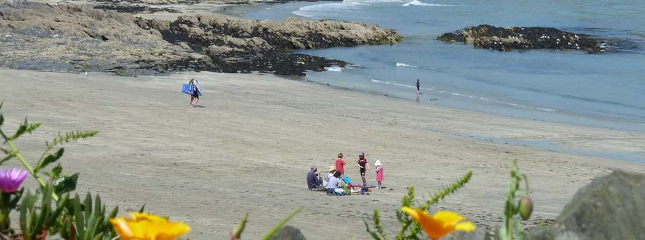 people sat on Porthcurnick beach