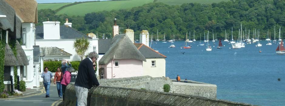 people enjoying the view of boats moored up in St Mawes